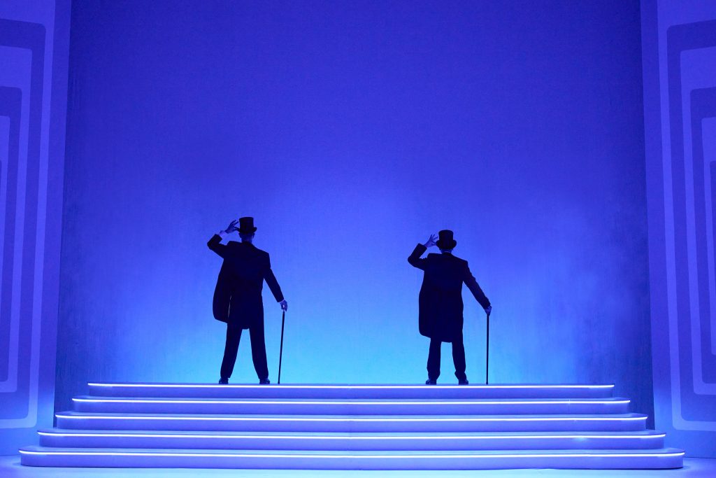 A production photo from The Play What I Wrote, showing two men facing the back of the stage wearing tails and top hats