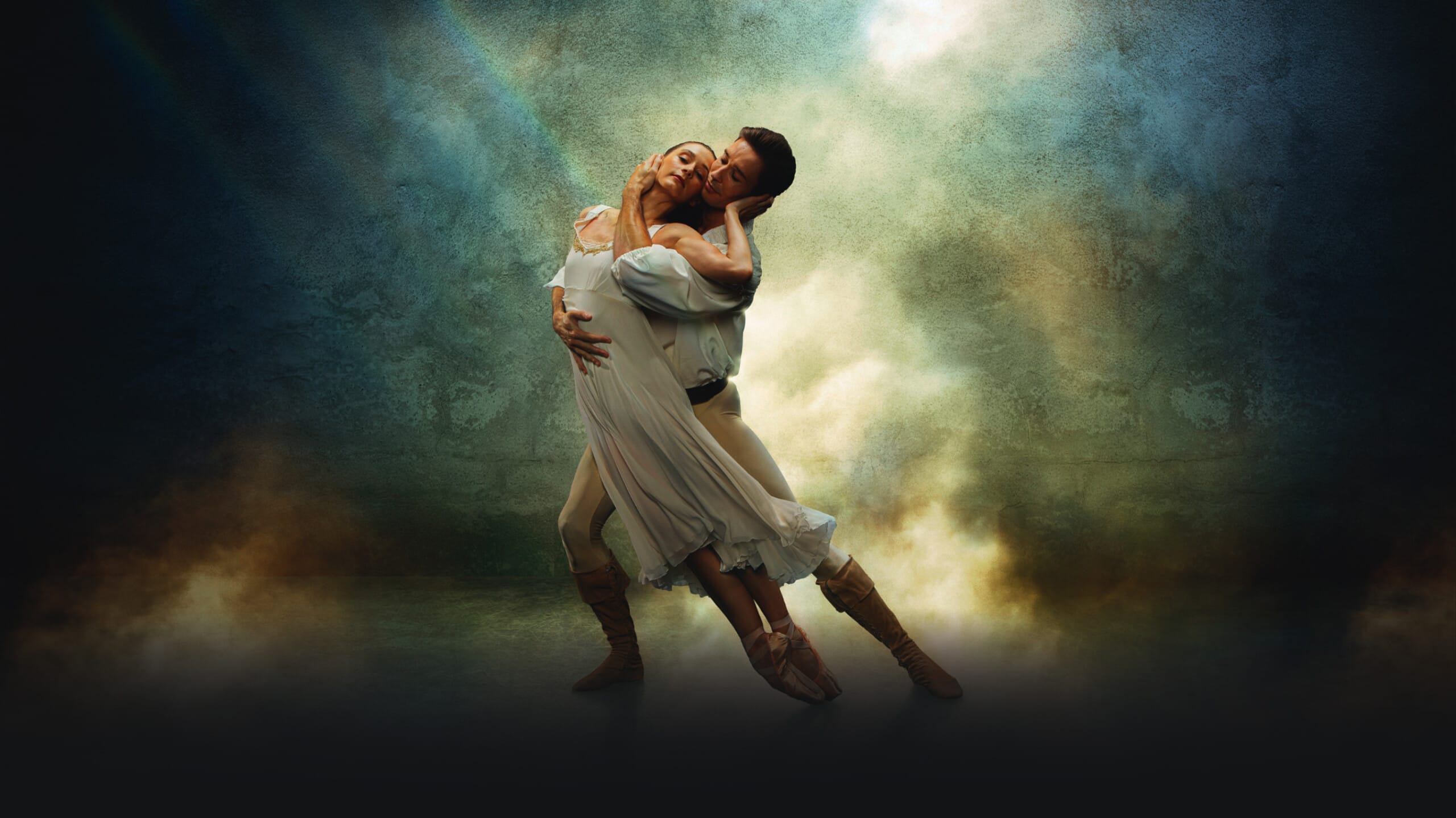 A male dancer holds a female dancer in an intimate embrace